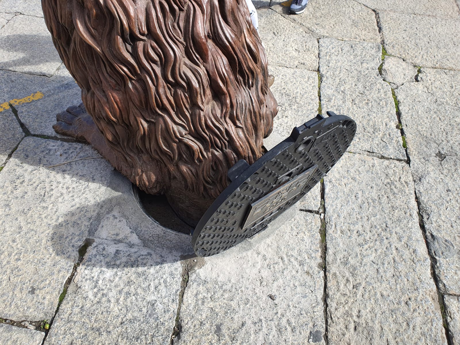 Escultura León saliendo de la alcantarilla