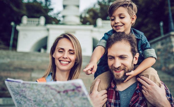 Happy family is having fun outdoors. Father, mother and son are spending time together while exploring new city.