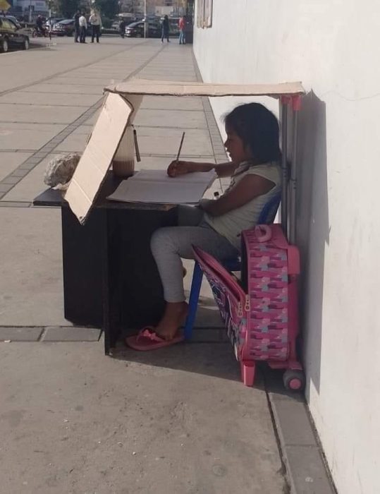 niña estudia debajo de una caja 