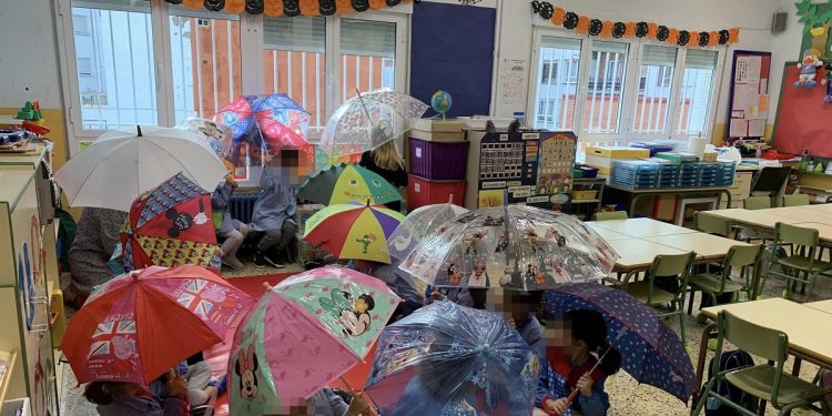 Lamentable imagen de niños con paraguas abiertos en clase