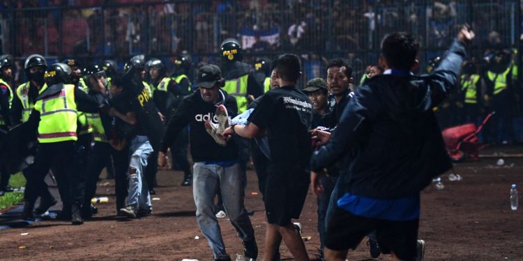 Aficionados lamentan la muerte de los 125 hinchas en Indonesia 1