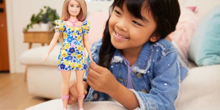 Niña jugando con la Barbie con síndrome de Down