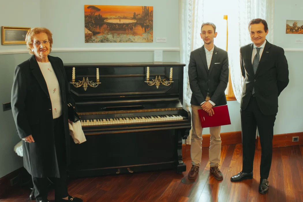 Emilia Fernández Díez, donante, Carlos Varela, conservador jefe del Museo Casa Botines Gaudí y Raúl Fernández Sobrino, director del Museo, posan con el piano colocado en la recreación de la vivienda.