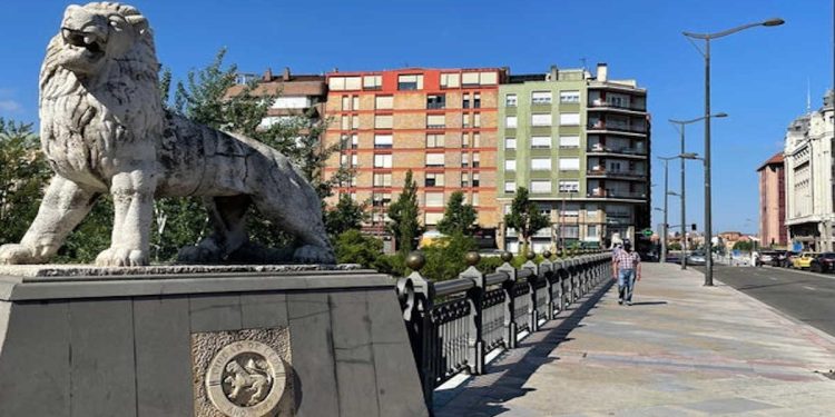 Sentado en la barandilla de un puente de León