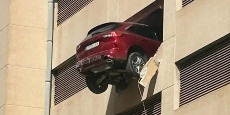 El coche acabó colgado en el parking